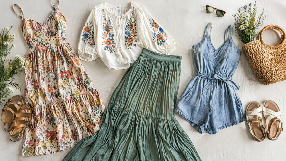 Flat lay of a floral dress, embroidered blouse and maxi skirt